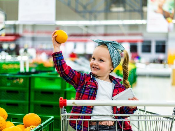 Little girl picking out oranges at the market